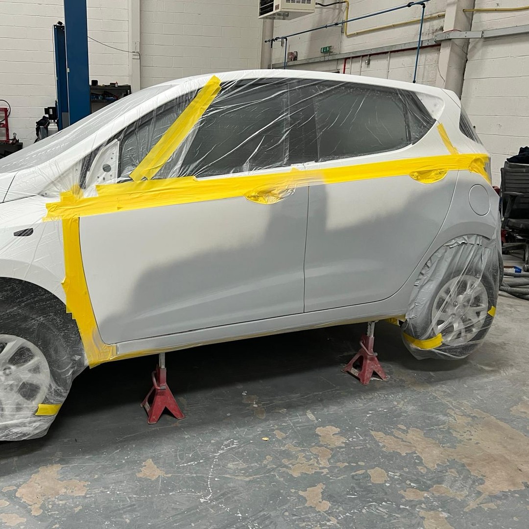 Close-up of repaired rear quarter panel and wheel arch on a white SUV